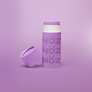 Nöz reef safe sunscreen shown in purple with cap off to show product texture.